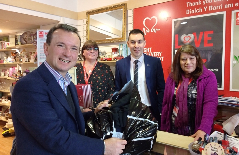 Front of till Alun Cairns MP, behind the till from left to right: Emma Harris BHF Assistant Shop Manager, Adam Fletcher, Head of BHF Cymru, and Pam Bear Volunteer.